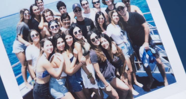 Une photo Polaroid d'un grand groupe de personnes sur un bateau.