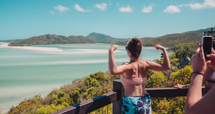 Une personne contemplant une vue panoramique sur des dunes de sable et l'océan.