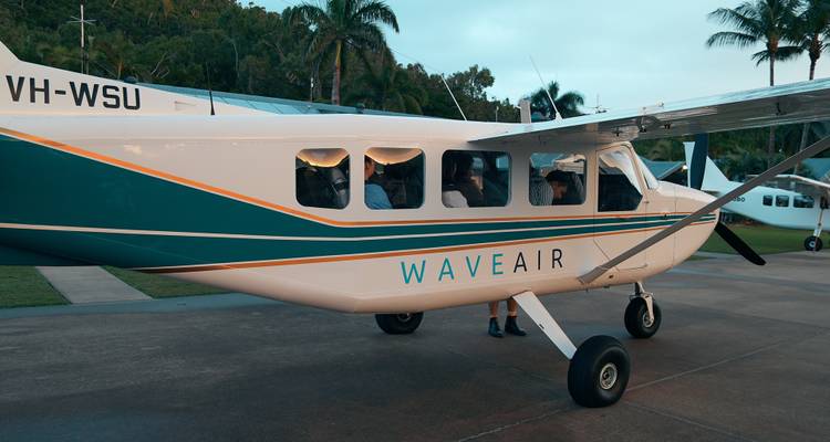 Un petit avion avec des passagers à l'intérieur garé sur un tarmac.