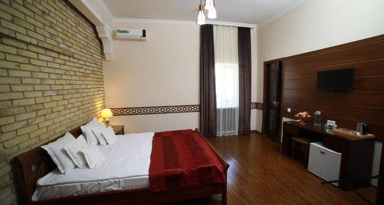 Gemütliches Hotelzimmer mit einer Backsteinwand und warmer Beleuchtung.