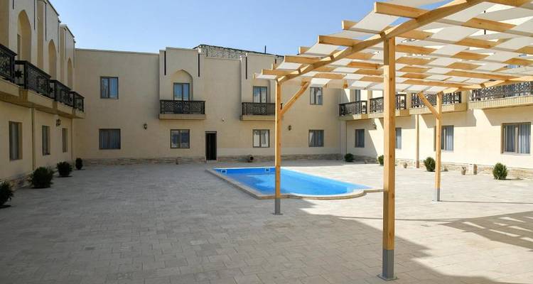 Innenhof mit einem kleinen zentralen Becken und Gebäudeaußenseite.