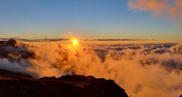 Majestic sunset over clouds with striking colors.