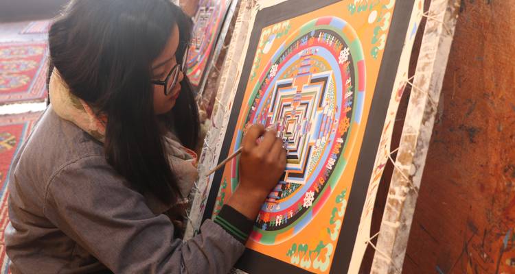 Artist painting a traditional Mandala artwork.