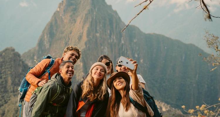 Groupe de randonneurs prenant un selfie avec le Machu Picchu en arrière-plan.