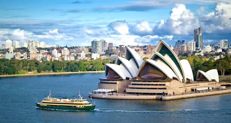Havenzicht met een beroemd operahuis en veerboot.