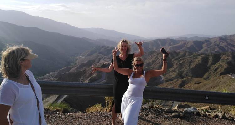 Gruppe von Menschen, die mit einer malerischen Berglandschaft im Hintergrund posieren.