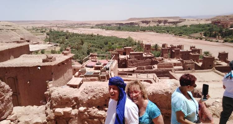 Touristen, die einen Panoramablick auf ein Wüstendorf genießen.