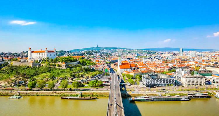Luchtfoto van een stad met een prominent kasteel en rivier.