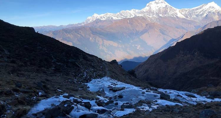 Ruig berglandschap met sneeuw en verre bergtoppen.