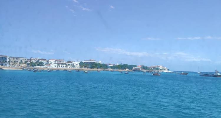 Vue d'une ville côtière depuis l'eau avec des bateaux à proximité.