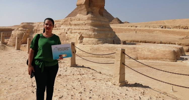 Frau posiert mit einem Schild vor der Großen Sphinx von Gizeh.