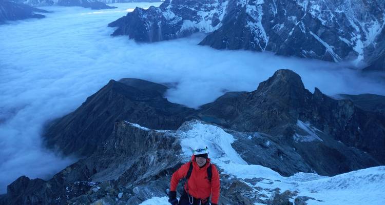 Persoon op een besneeuwde bergkam met panoramisch uitzicht