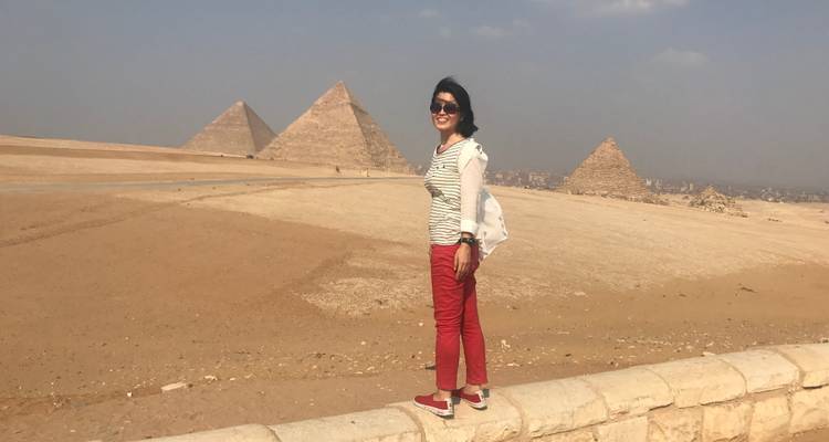 A person standing in front of the Pyramids of Giza.