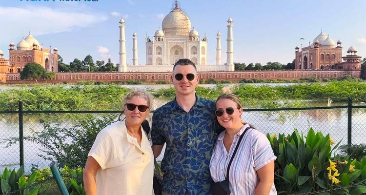 Trois personnes devant le Taj Mahal, un célèbre monument indien.