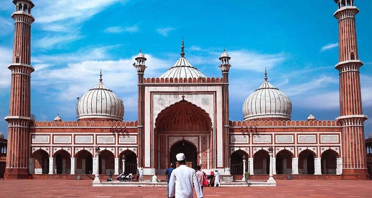 Complexe de mosquée avec une personne en tenue traditionnelle.