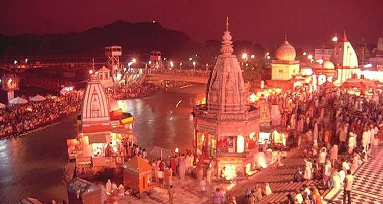 Avondscène aan een rivier met tempels en mensen die samenkomen.