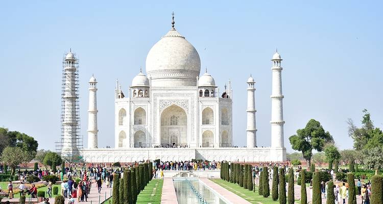 De Taj Mahal met een heldere blauwe lucht en weelderige groene tuinen.