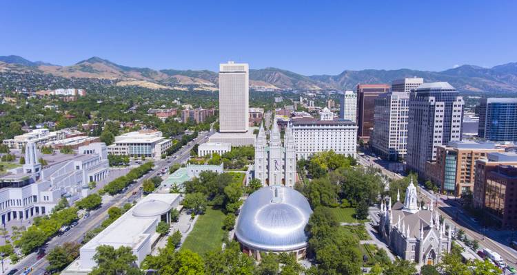 Aerial view of a city with modern buildings and a mountainous background.