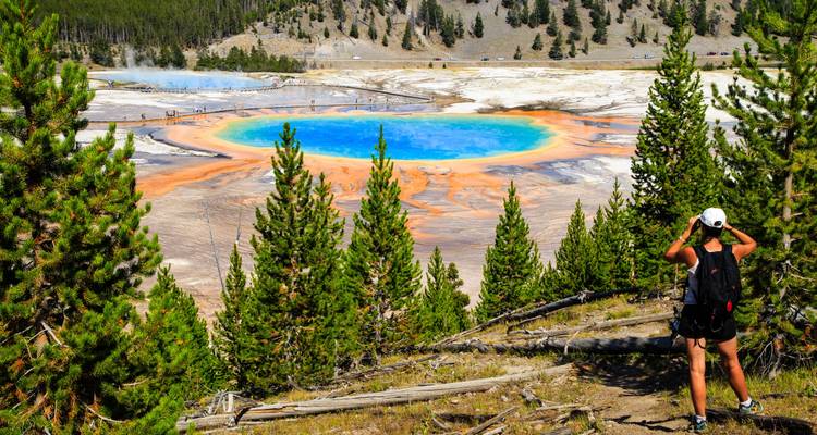 Traveler taking a photo of the Grand Prismatic Spring in Yellowstone.