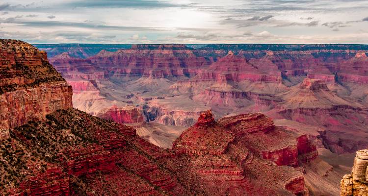 El vasto cañón estratificado del Gran Cañón se extiende hacia el horizonte bajo unas nubes dramáticas.
