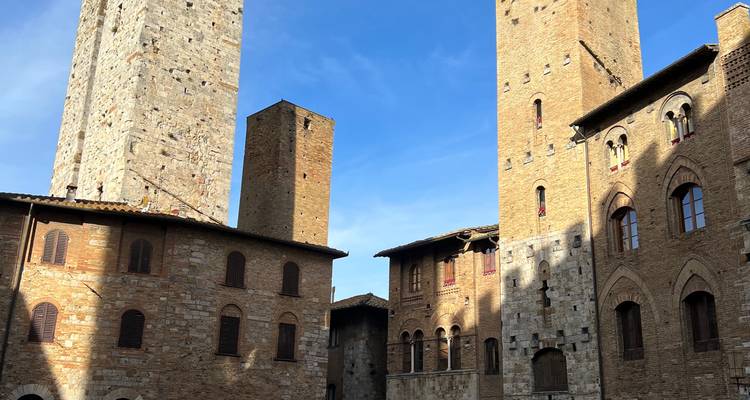 Historische torens in een middeleeuwse stad onder een heldere blauwe hemel.