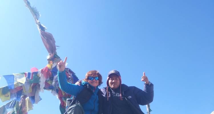 Zwei Menschen lächeln und posieren mit Gebetsfahnen.