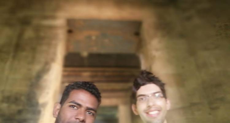 Twee mensen die een selfie maken met een wazige achtergrond van oude stenen.