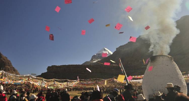 Festival con banderas coloridas cerca de montaña sagrada.