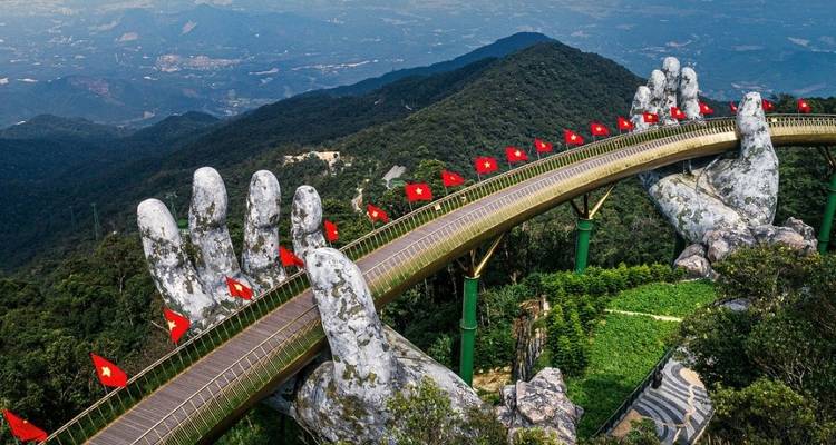 Goldene Brücke mit großen skulptierten Händen in nebliger Landschaft
