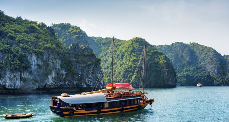 Traditionelles Boot auf einer ruhigen Bucht mit Kalksteinhügeln.