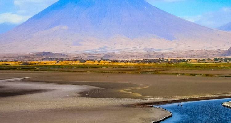 Scenic view of a vast landscape with a lone mountain in the background.