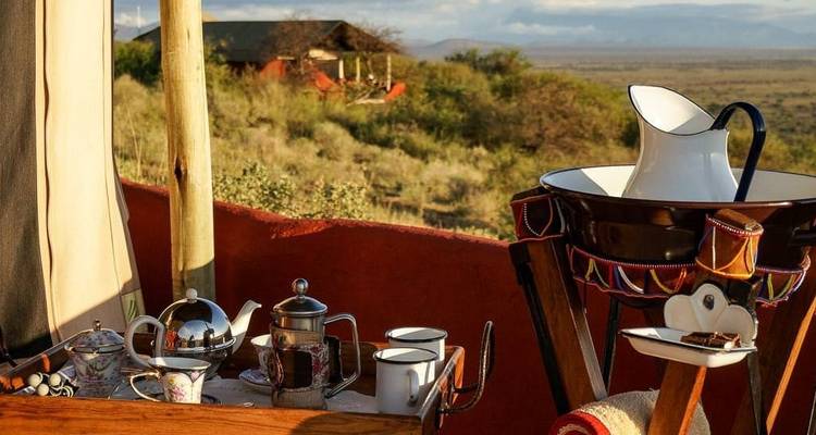 Outdoor setup with tea and coffee pots overlooking a scenic landscape.