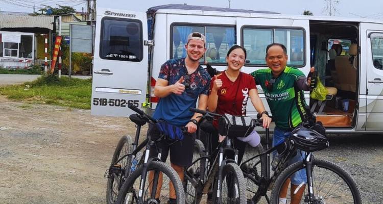 Gruppe von Personen mit Fahrrädern, die vor einem Van posieren.