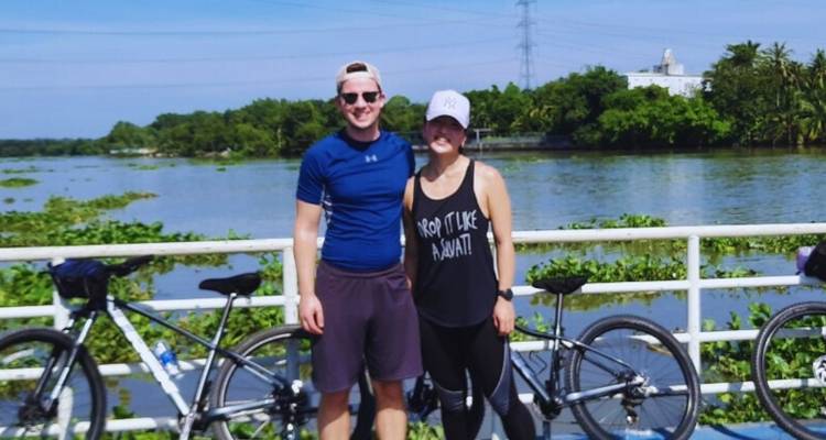 Paar posiert mit Fahrrädern an einem Fluss.