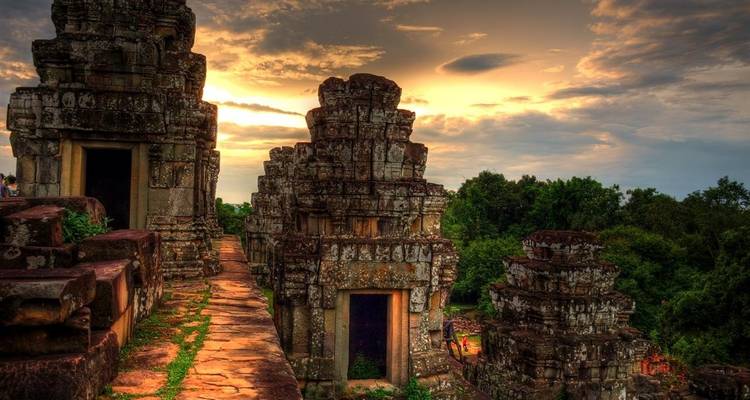 Ancient temple structures under a dramatic sky at dusk.