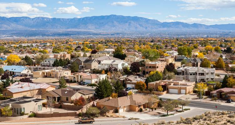Een luchtfoto van een woonwijk met bergen op de achtergrond.