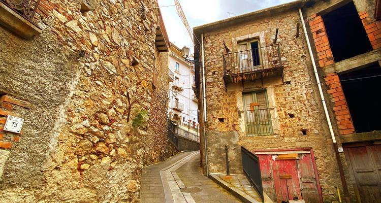 Rustieke stenen gebouwen langs smalle historische straat.