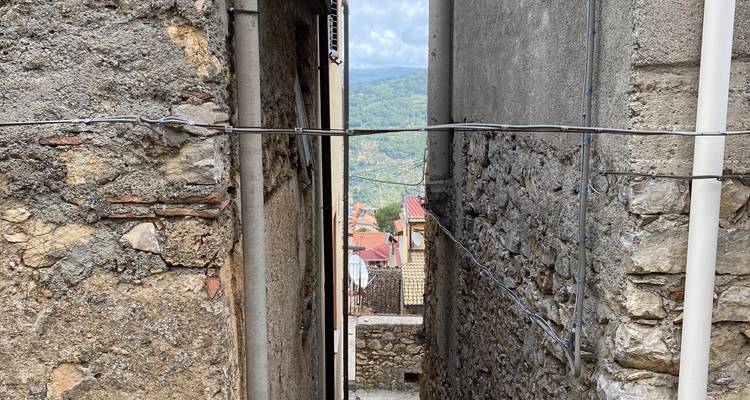 Smalle steeg tussen stenen gebouwen.