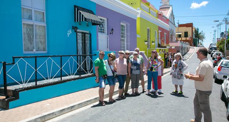 Group of tourists with colorful houses in Cape Town.