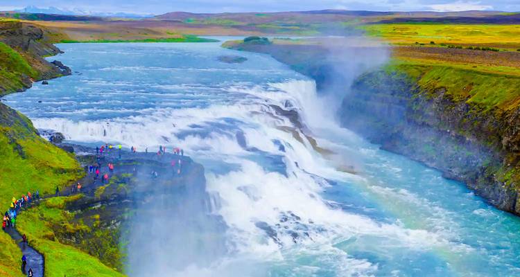 Vaste cascade avec des touristes observant depuis les sentiers.