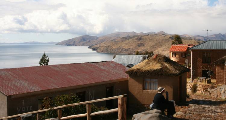 Vue de maisons donnant sur un grand lac entouré de collines.