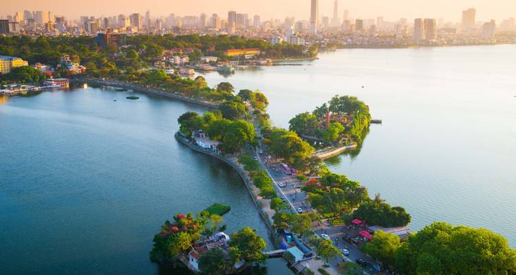 Aerial view of an urban area with greenery surrounded by water in Hanoi.