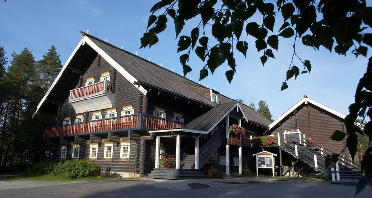 A rustic log cabin surrounded by trees.