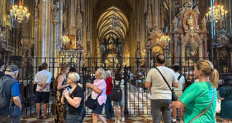 Intérieur d'une cathédrale avec des touristes observant des détails complexes.