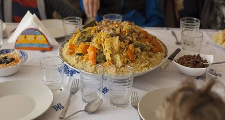 Gedeelde maaltijd op een tafel met couscous als middelpunt.