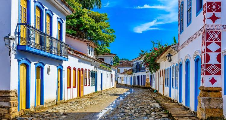 Helder gekleurde koloniale straat met sierlijke gevels en een heldere blauwe lucht.