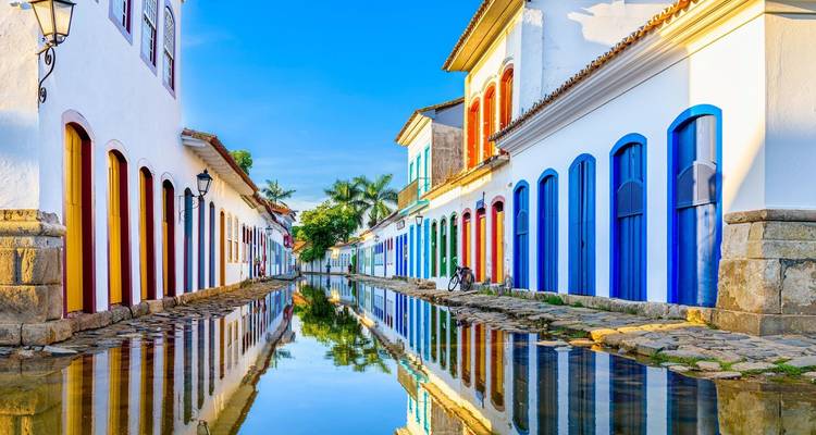 Levendige koloniale straat met reflecties en kleurrijke deuren.