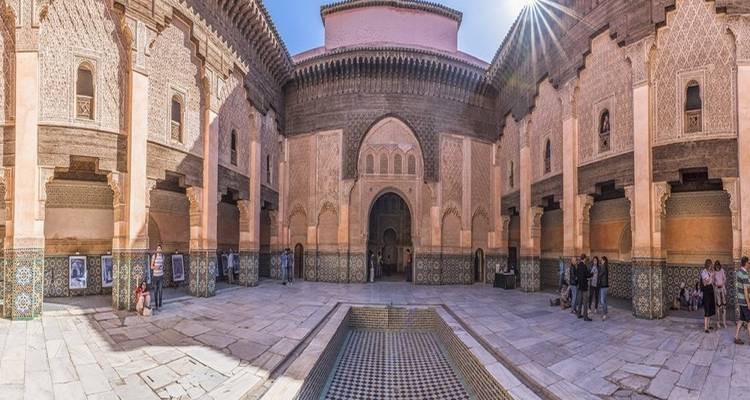 Cour historique avec un carrelage complexe et des arches.