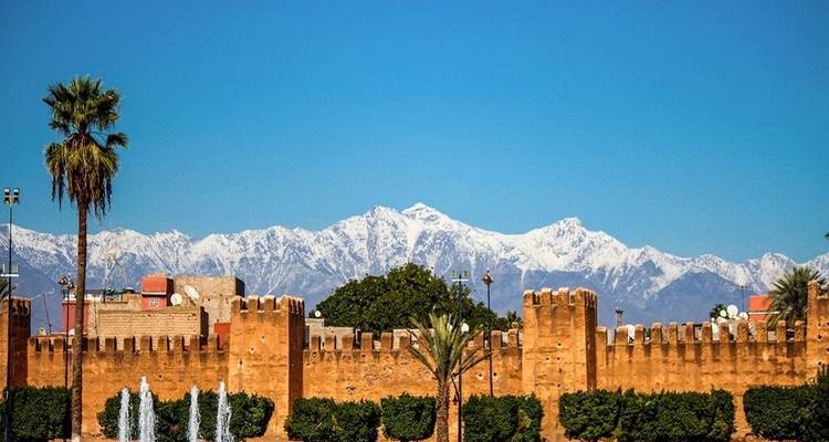 Stadsgezicht met oude muren en met sneeuw bedekte bergen op de achtergrond.