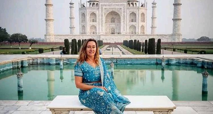 Femme en tenue traditionnelle posant devant le Taj Mahal.